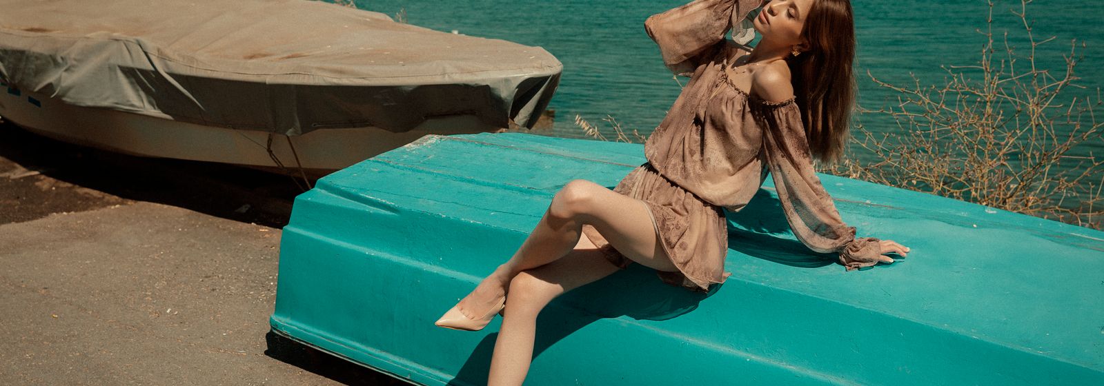 Femme élégante en tenue estivale légère au bord de la mer — Vogue Française